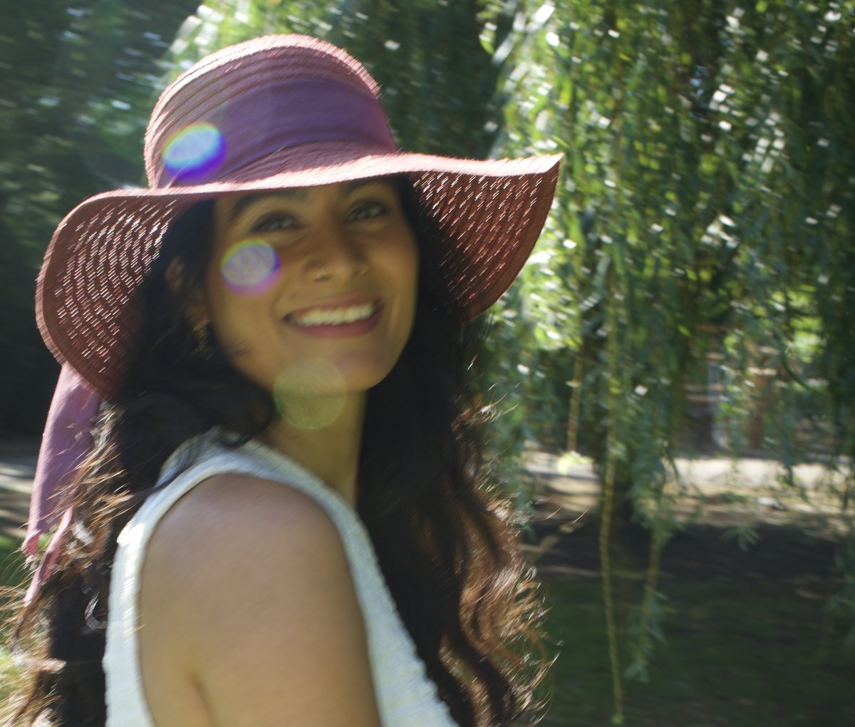 Founder Abilasha smiling in a sun hat